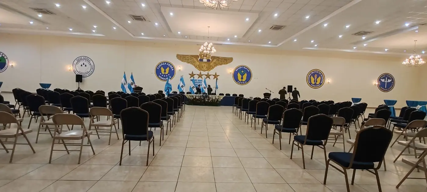 Salón real preparado para evento corporativo con mesas vestidas y decoración